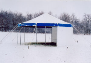 White pole tent set up on a snowy day