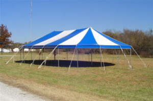 White and blue event tent set up in a field