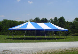 Blue and white pole tent set up in a field