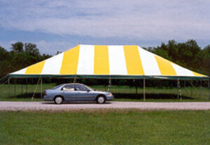 Yellow and white pole tent set up in a field