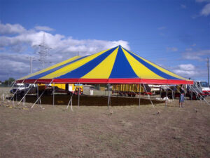 Blue and yellow firework tent set up in a field