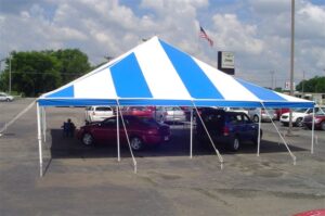 Blue and white pole tent set up in a car lot