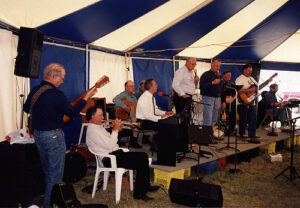A band playing under a blue and white tent