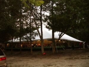 All white party tent set up around some trees