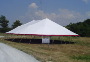 Large white pole tent set up outside of Miami Missionary Tent Co