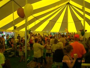 People gathered under a large pole tent for an event