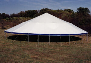A white pole tent with blue valance set up in a field