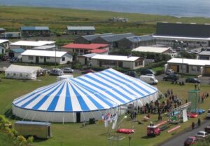 Large blue and white event tent in a field