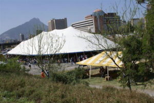 Large all white pole tent with a smaller yellow and white tent next to it