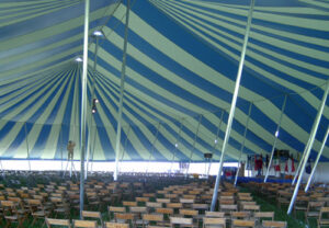 Under a large blue and white pole tent