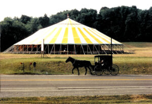 Miami Missionary Tent Co founder standing on top of a very large pole tent