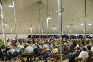 Group of people gathered under a revival tent